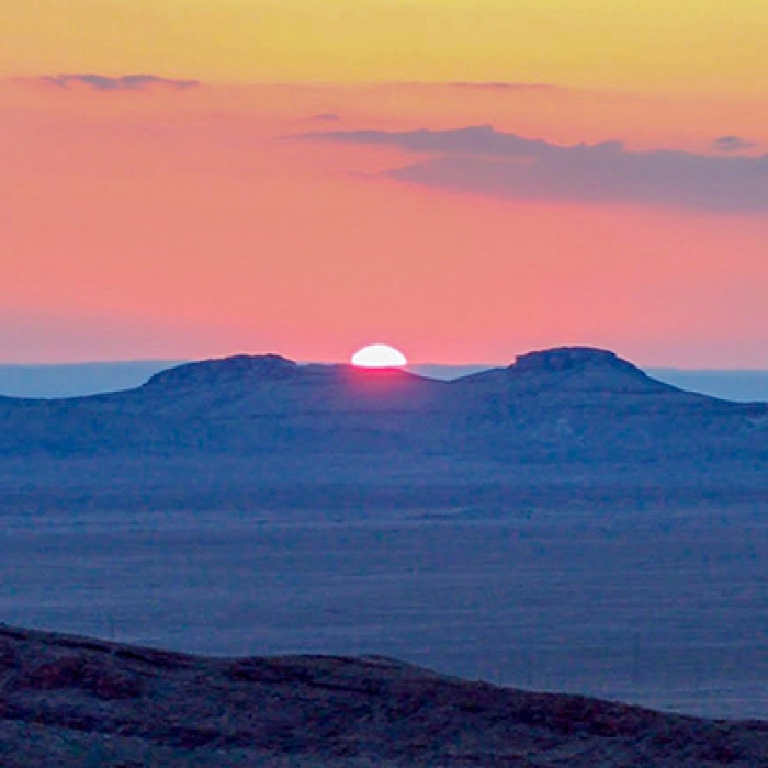 Syrian desert with sun setting behind mountains