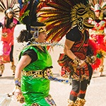 Mexican dancers in cultural dress and wearing masks