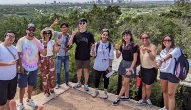 Will Slade and students smile with Austin's greenbelt and downtown skyline in background