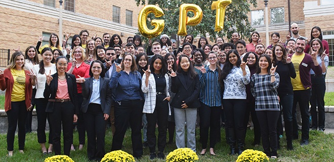 students pose together with GPT balloons at the conference